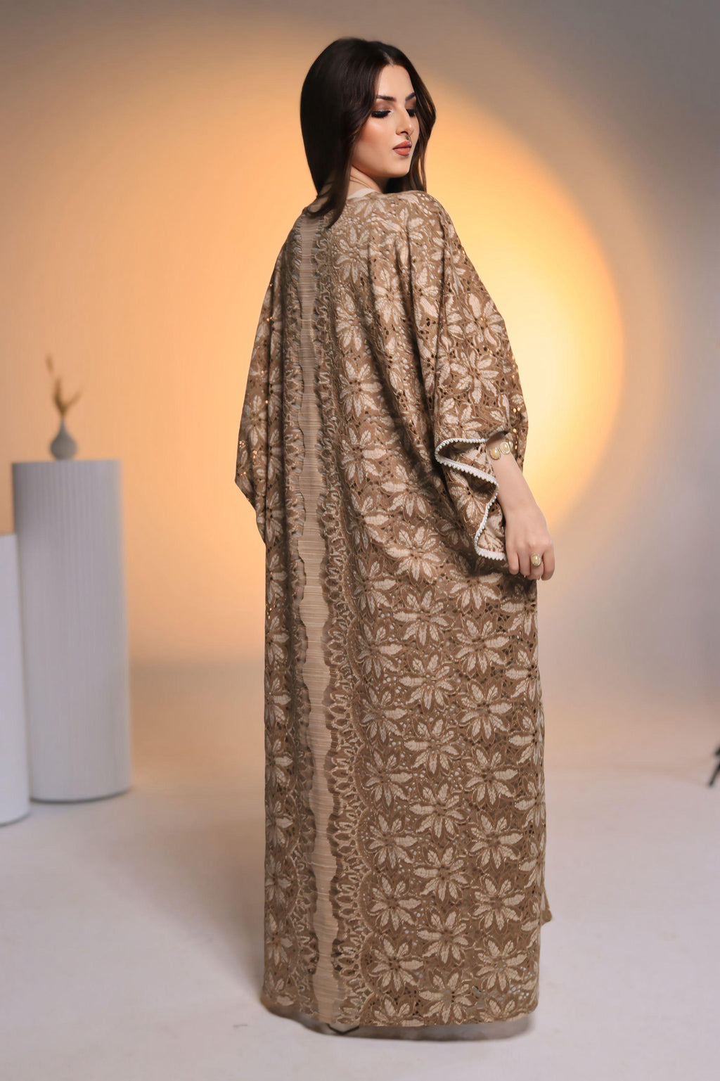 Woman wearing a brown floral dress against a neutral background